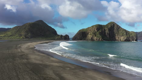 Flight-towards-Whatipu-beach-with-rocky-formations-Huia-Reserve,-New-Zealand