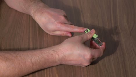 man's hands clipping his fingernails with a clipper on a table