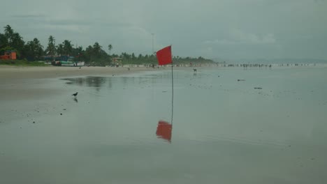 beachside view of a red warning flag for high hazard waters on a cloudy day in asia