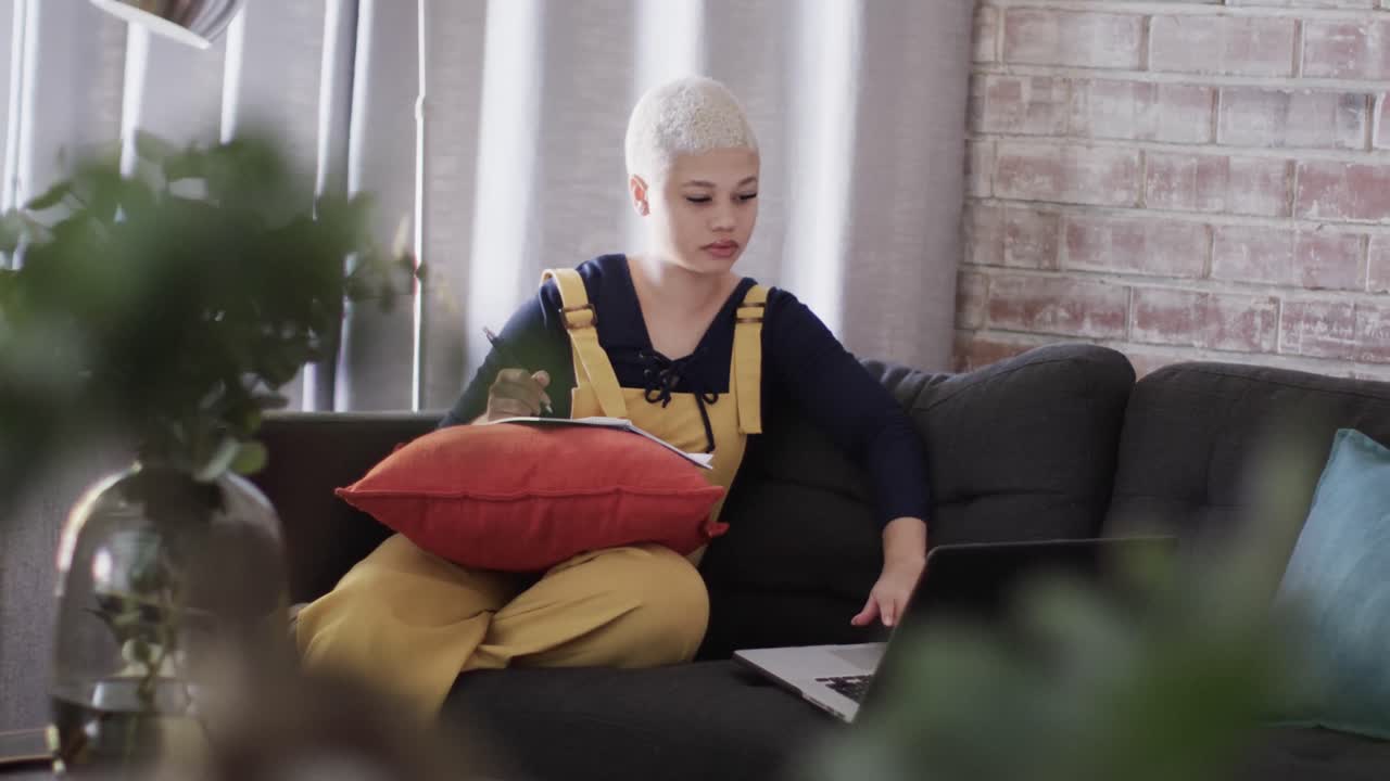 슬로우 모션으로 소파에 노트북을 가지고 집에서 일하는 바쁜 두 인종의 여성