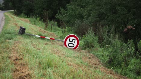 señal de límite de velocidad de 50 kilómetros con bandas de seguridad rojas y blancas en el lado del campo