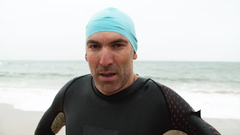 serious male swimmer looking at camera at the beach