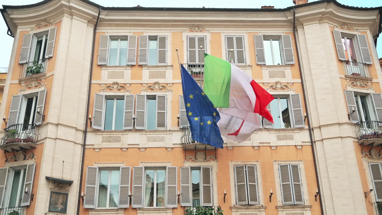 Facciata di un edificio residenziale in stile classico con bandiere a Roma, Italia