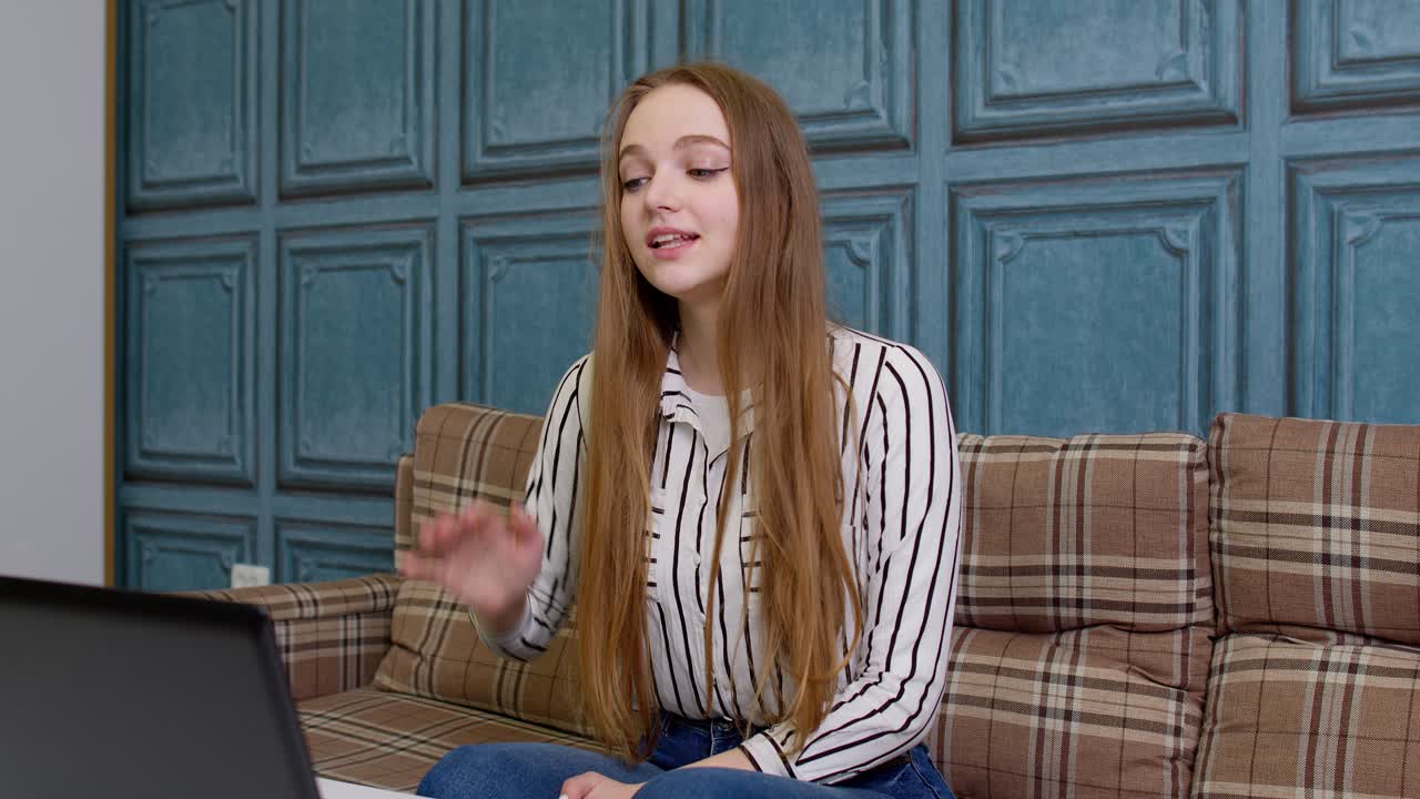 chica agitando la mano hola hola, hablando mirando a la computadora portátil, llamada de video con el maestro