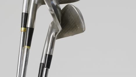 Close-up-of-golf-clubs-on-white-background,-copy-space,-slow-motion