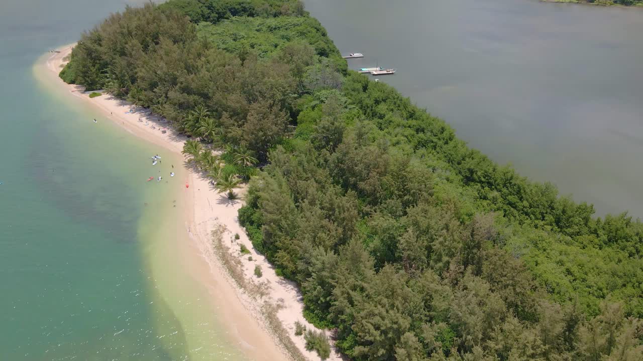 An aerial shot captures the breathtaking beauty of Kane'ohe Bay, Moli'i Fish Pond, and distant mountains against the sky