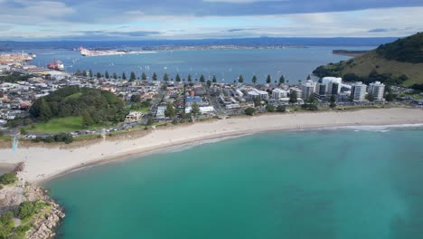 aerial view of a coastal town with a long beach and busy harbor