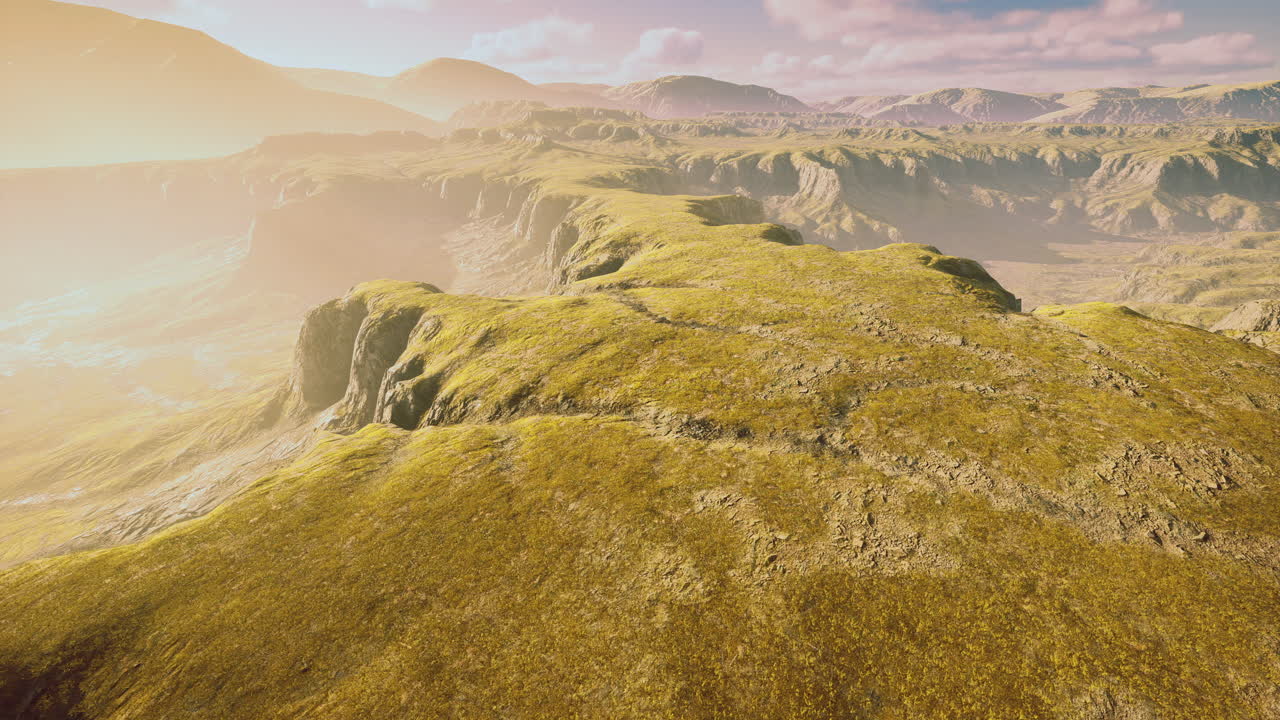 Expansive grassy landscape under golden sunlight at dawn in remote terrain