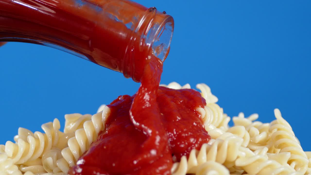 토마토 소스는 은 파스타 푸실리 한 어리 병에서 부어.