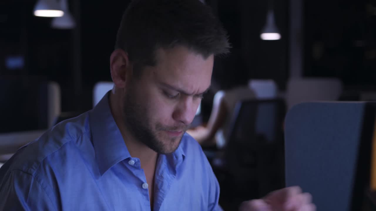 Businessman working in a modern office by night