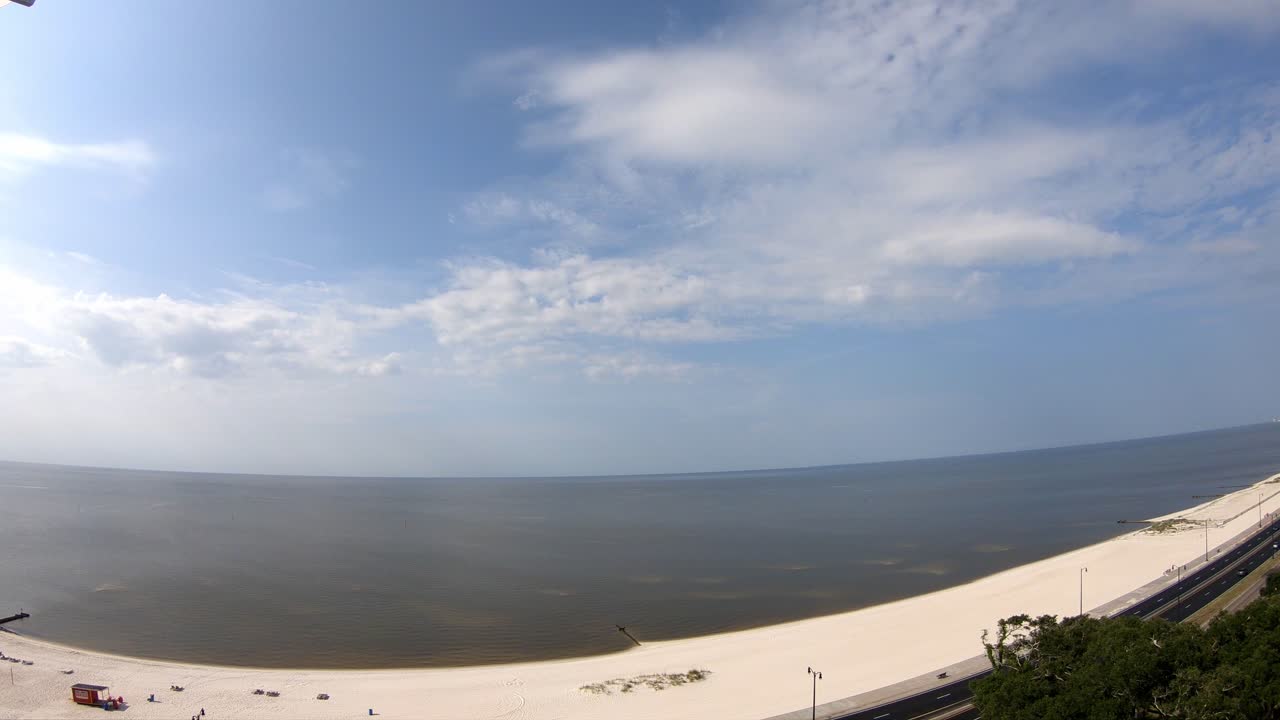 vista diurna de la playa en lapso de tiempo: océano, muchas nubes activas, viento que sopla agua por todas partes - vista del piso 14 de una playa casi sin olas en el golfo