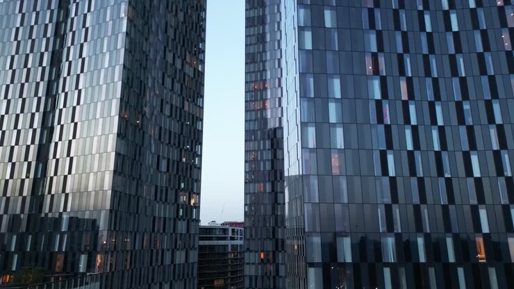 Vuelo de dron en la base de las Torres Elizabeth en el Centro de Mánchester con una inclinación lenta hacia arriba para revelar las torres