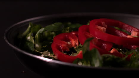 red pepper slices falling on lettuce