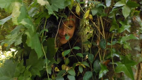 woman hiding in bushes at forest 4k