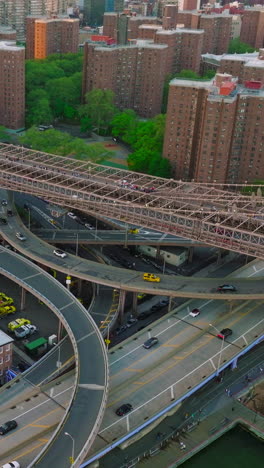 numerous roads passing under the brooklyn bridge. dense architecture of new york city with busy traffic. vertical video