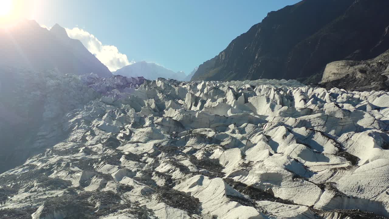 여름에 훈자 파키스탄에서 일몰 동안 태양 플레어와 함께 파수 빙하를 드러내는 공중 드론 패닝