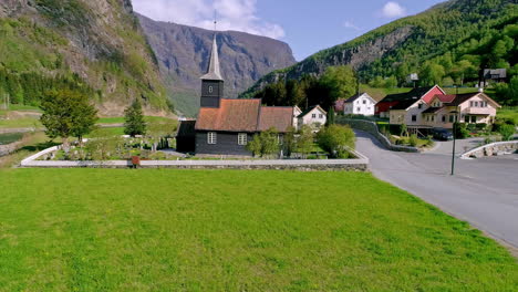 small village with a church in a valley in norway - aerial