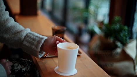 mujer bebiendo café en una cafetería