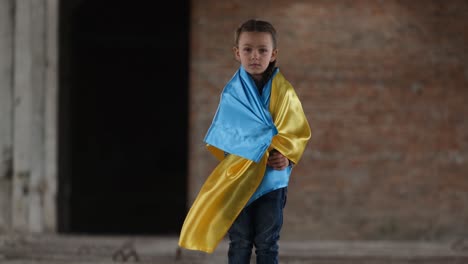 an upset child with a ukrainian flag in the middle of a destroyed building