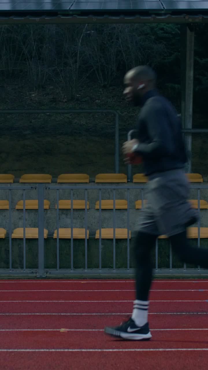 Man running on a stadium track in the winter