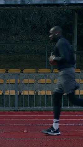 man running on a stadium track in the winter