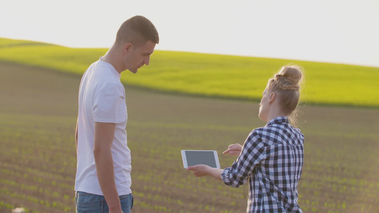 Couple On Farm Talking In Field Of Green Plants 1