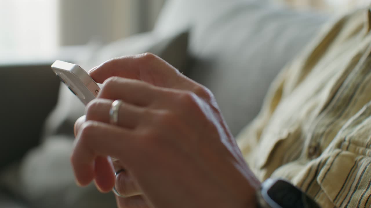 persona usando un teléfono inteligente en un sofá