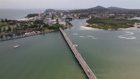 cars driving through head street bridge over coolongolook river between forster and tuncurry in nsw, australia. - aerial shot