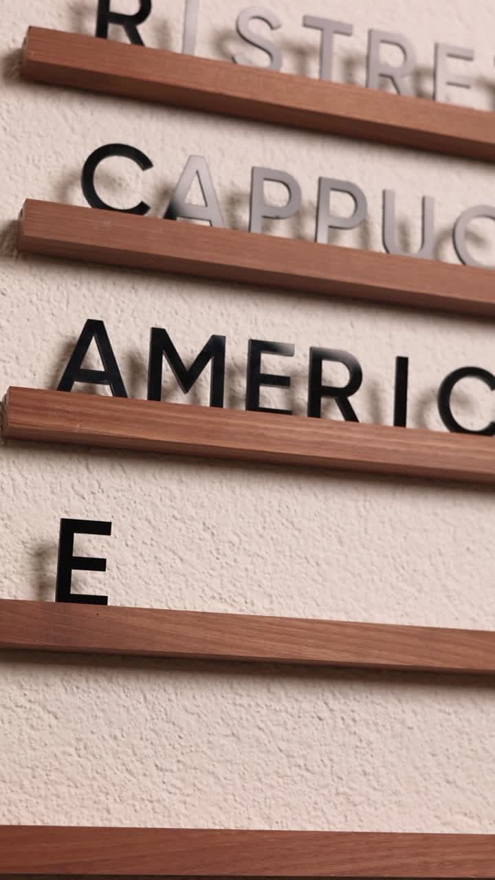 Hand placing a drink order on a coffee shop menu board