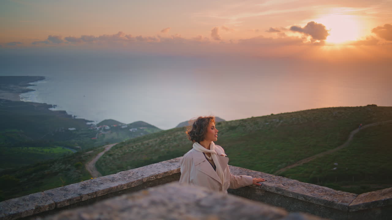 Lächelnde Frau genießt Sonnenuntergang mit Blick auf einen malerischen Horizont. Stilvolle Reisende entspannt sich