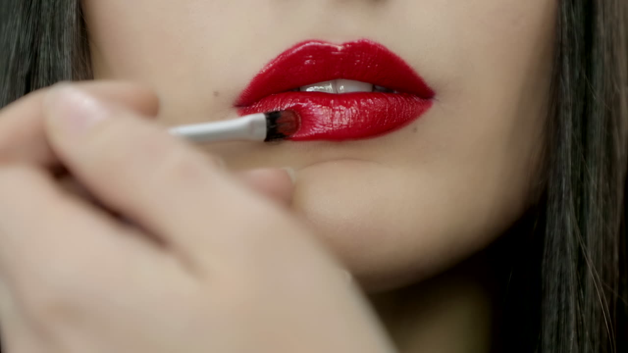 mujer aplicar lápiz labial rojo
