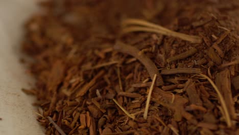 macro shot of hands picking up dried madder root powder, natural organic herb extract