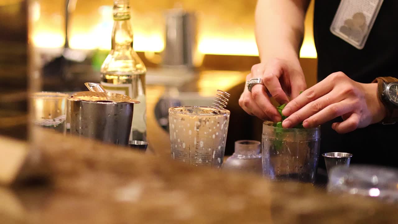 un camarero preparando bebidas en un mostrador de bar