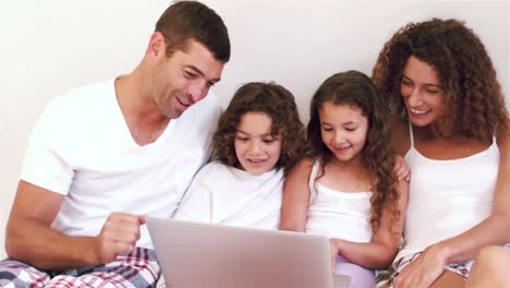 Nette-Familie,-Die-Laptop-Computer-Auf-Ihrem-Bett-Benutzt