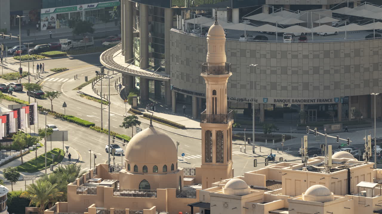 Veduta dall'alto di una moschea e un minareto in un vivace paesaggio urbano di Dubai.