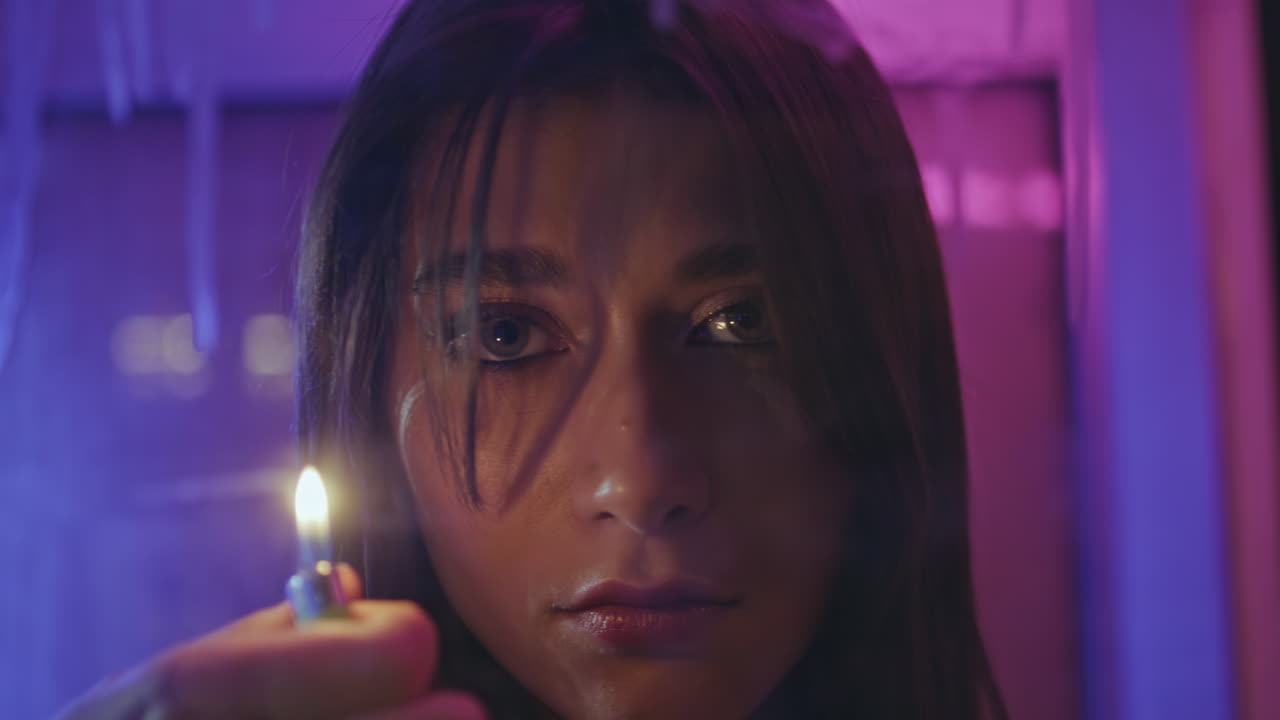 Neon girl holding lighter in night club portrait. Serious woman posing closeup