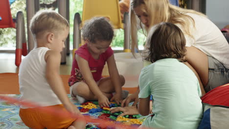 Grupo-De-Niños-Jugando-Con-El-Maestro-De-Escuela