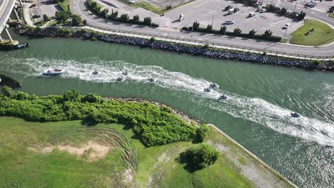 a line of small watercraft leaving rudee inlet in virginia beach, virginia for the atlantic ocean