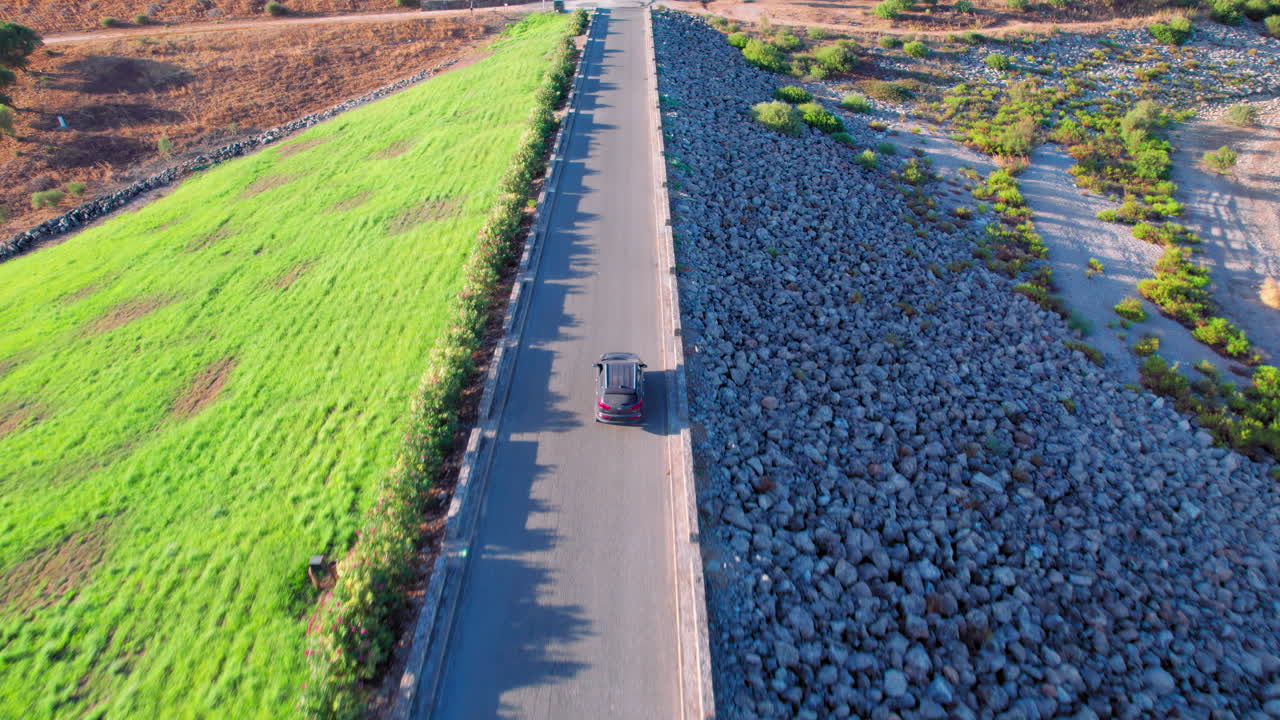 Car driving on dam road with scenic landscape