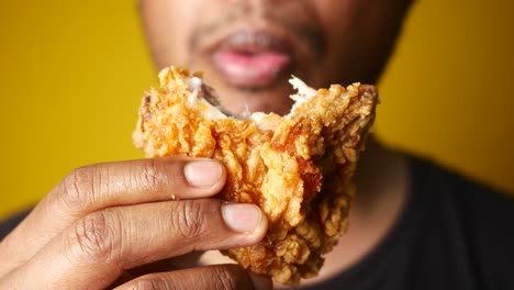 man eating a crispy fried chicken wing