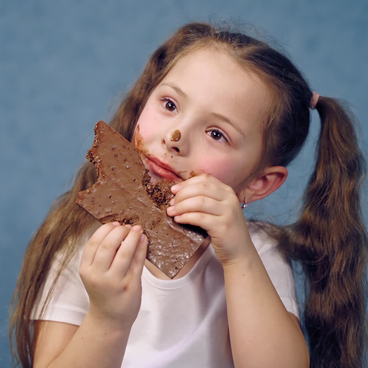 Young girl eating chocolate bar