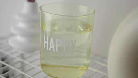 a glass with the word "happy" on it filled with water