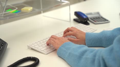 office worker typing on white keyboard