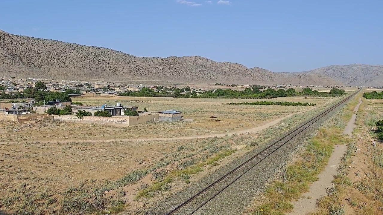 Vista panoramica di un villaggio rurale e binari ferroviari in un paesaggio desertico