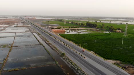 aerial view of highway cutting through rural jacobabad with water logged fields on left hand side