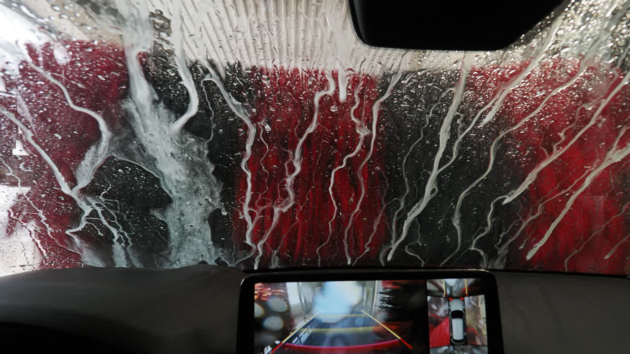 espuma de jabón de colores en el coche durante el proceso de limpieza