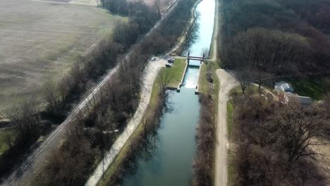 Aerial-drone-view-of-the-Hennepin-Canal-and-Parkway-Trail-with-empty-fields-in-the-distance-in-early-spring-near-Colona-Illinois