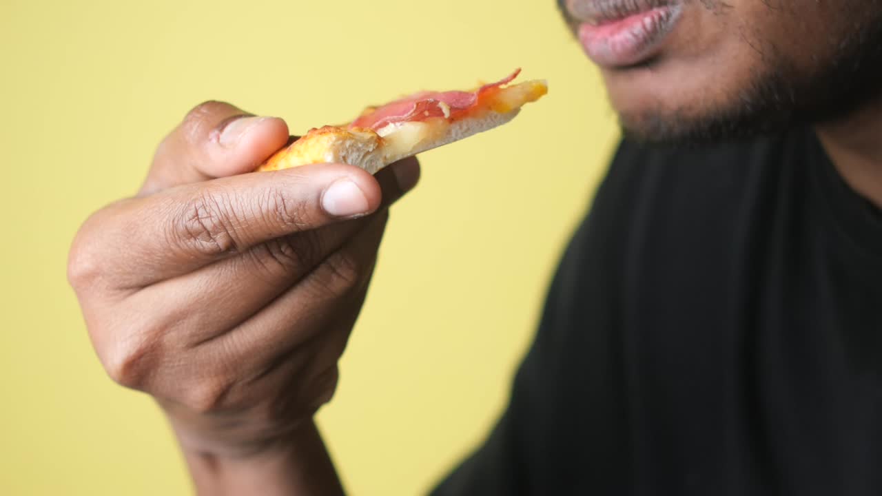 persona comiendo una rebanada de pizza