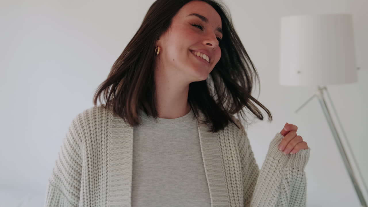 Happy Young Woman Dancing and Smiling Joyfully at Home