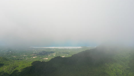 high altitude aerial shot of highlands of party island koh phangan with fog stream